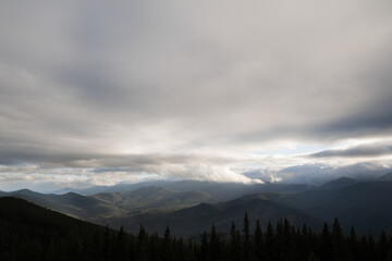 Fototapeta na wymiar Dark dramatic clouds over mountains, mountain landscape, autumn morning view of mountain ranges