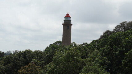 The lighthouse and the sky in the middle of the trees that look like green mosaic