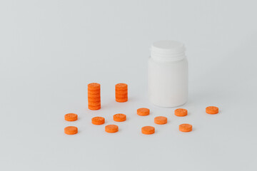 Medical orange pills on a white background stand on top of each other near the bottle. Medicine, with copy space