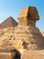 The statue of the Great Sphinx on the Giza plateau against the background of the Egyptian pyramid....