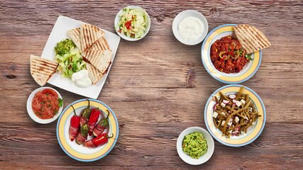 Textured walnut wooden table with Mexican food animated and view from above