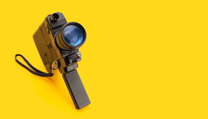 Super 8 movie camera isolated on yellow background. Cinema background. Copy space