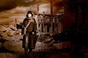 A man in a gas mask on a dramatic background of lifeless ruins. Selective focus.