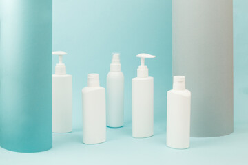 Set of white cosmetic bottles with soft shadows on light blue background. Home and beauty salon care concept, mock up, copy space, beauty industry banner, flyer, coupon, healthcare