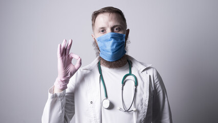 Male doctor in laboratory coat on gray background