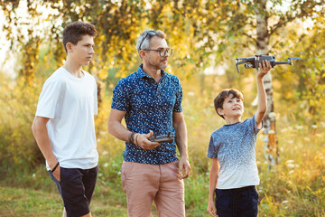 Father and sons launch a drone in the garden
