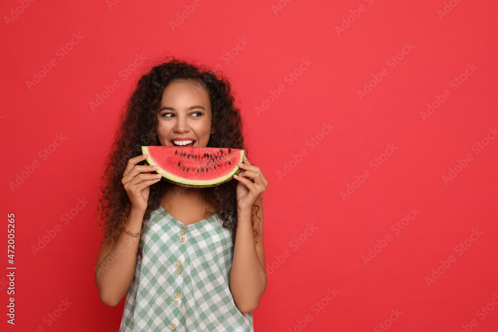 Poster Beautiful young African American woman with slice of watermelon on red background. Space for text