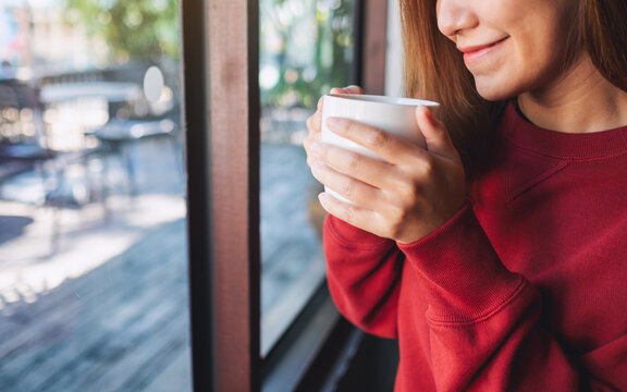 Closeup Image Of A Young Woman Holding And Drinking Hot Coffee