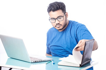 serious business man working on laptop and searching something on a notebook diary