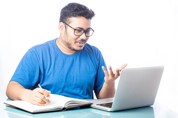 young man smiling and talking with someone on video chat using laptop