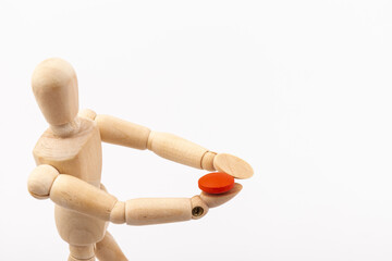 Wooden mannequin with pills on white background. Concept of pharmaceuticals and supplements.