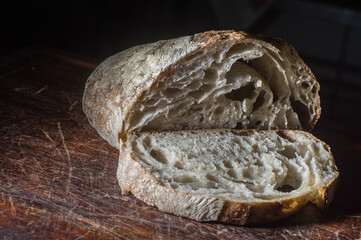 Pão integral colocado na placa de madeira da cozinha, Pão fresco na mesa close-up.  Pão fresco na mesa da cozinha O conceito de alimentação saudável e padaria tradicional
