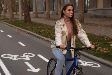 Happy beautiful woman with bicycle on lane in city