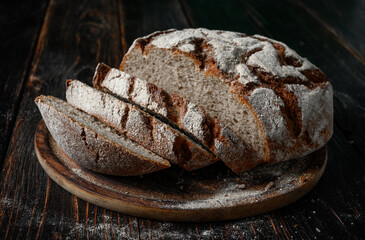 Homemade rye bread. Rye bread in a round shape on a wooden background in a rustic style with bread...