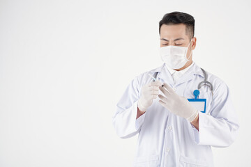 Serious doctor in medical mask and protective gloves preparing syringe with vaccine for injection