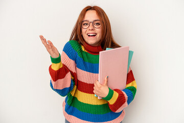 Young student caucasian woman isolated on white background receiving a pleasant surprise, excited and raising hands.