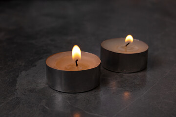 Two burning candles on the table closeup