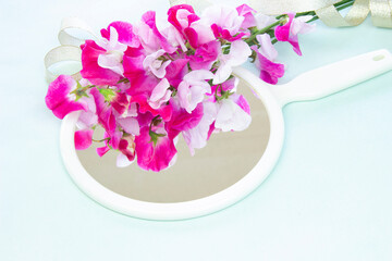 手鏡に映るピンクと白のスイトピーの花束