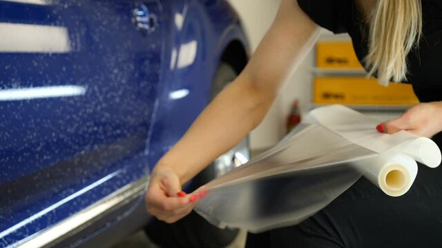 Close up to PPF installation process on a front headlight and hood. PPF is a Paint Protection Film which protect paint from scratches and stone chips. Concept of: Guard, Protect, Car, New, Work.	
