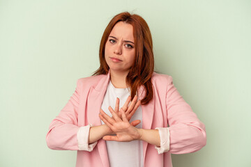 Fototapeta premium Young caucasian woman isolated on green background doing a denial gesture
