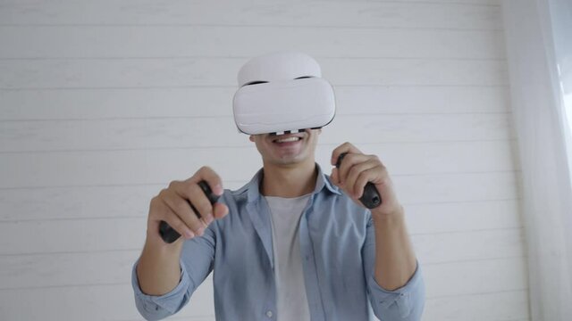 Young hispanic man wearing virtual reality headset playing simulation boxing game on weekend at home