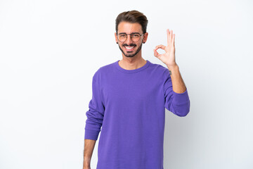 Young caucasian man isolated on white background showing ok sign with fingers