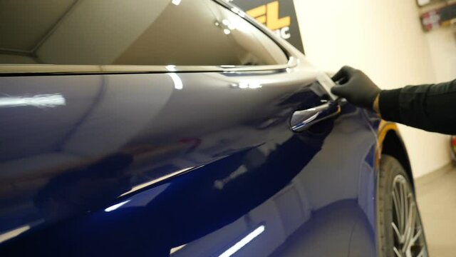Close up to PPF installation process on a front headlight and hood. PPF is a Paint Protection Film which protect paint from scratches and stone chips. Concept of: Guard, Protect, Car, New, Work.	
