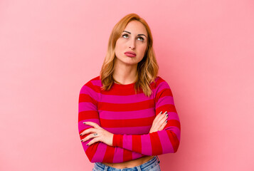 Young caucasian woman isolated on pink background tired of a repetitive task.