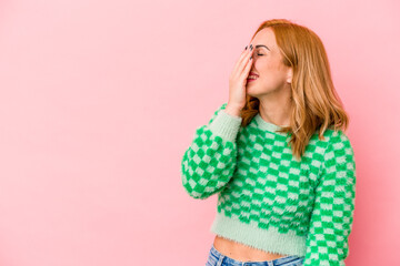 Young caucasian woman isolated on pink background laughing happy, carefree, natural emotion.