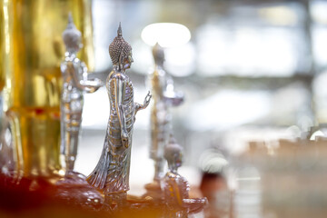 Silver shining Buddha statue with gold and silver background.