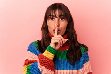 Young Argentinian woman isolated on pink background keeping a secret or asking for silence.