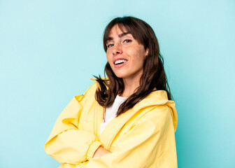 Young Argentinian woman isolated on blue background who feels confident, crossing arms with determination.