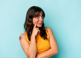 Young Argentinian woman isolated on blue background contemplating, planning a strategy, thinking about the way of a business.