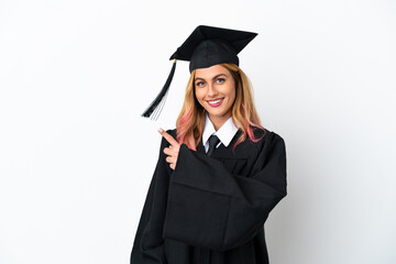 Young university graduate over isolated white background pointing to the side to present a product