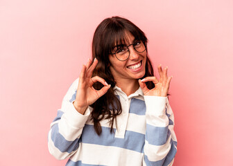 Young Argentinian woman isolated on pink background cheerful and confident showing ok gesture.