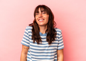 Young Argentinian woman isolated on pink background laughs and closes eyes, feels relaxed and happy. - obrazy, fototapety, plakaty