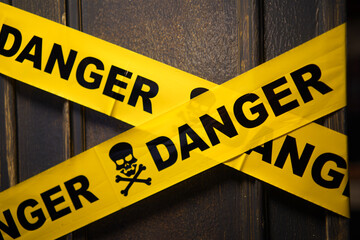 Danger Yellow Tape Warning in front of the closed wooden door