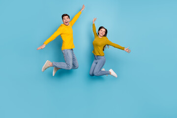 Full length photo of crazy excited lady guy jump play game fly bird isolated over blue color background