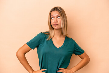 Young caucasian woman isolated on beige background confused, feels doubtful and unsure.