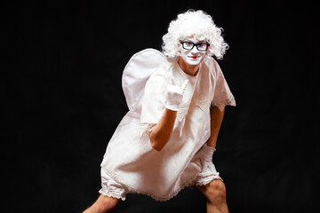 Portrait of male mime artist, isolated on black background. Young man in the image of an angel and...