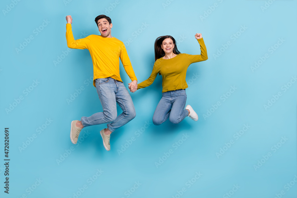 Poster Full length photo of excited lady guy spouses jump up raise fists win lottery discount isolated over blue color background