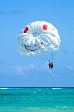 White parasailing  with 2 people towed at beach in Punta Cana