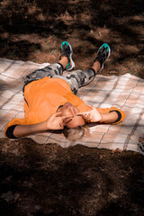 Young guy at the picnic. The man is resting on the bedspread.