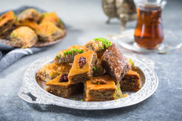 Traditional Turkish Desserts Baklava with  Tea. Crispy mix baklava on silver  plate.