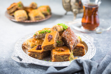 Traditional Turkish Desserts Baklava with  Tea. Crispy mix baklava on silver  plate.