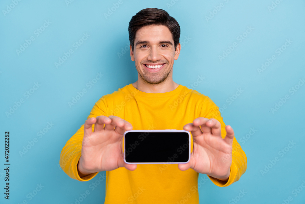 Sticker Photo of millennial guy hold touch screen smart phone recording selfie portrait isolated over blue color background