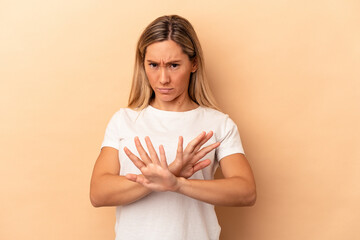 Young caucasian woman isolated on beige background doing a denial gesture