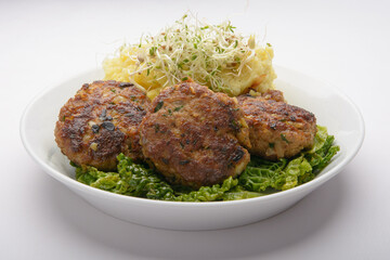 studio shot of meatballs with mashed potatoes and bean sprouts as decoration against a white background