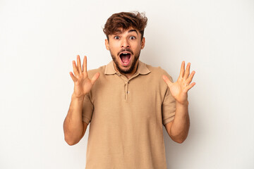 Young mixed race man isolated on grey background celebrating a victory or success, he is surprised and shocked.