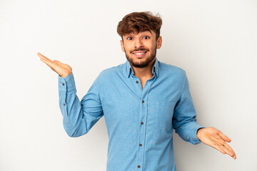 Young mixed race man isolated on grey background confused and doubtful shrugging shoulders to hold a copy space.